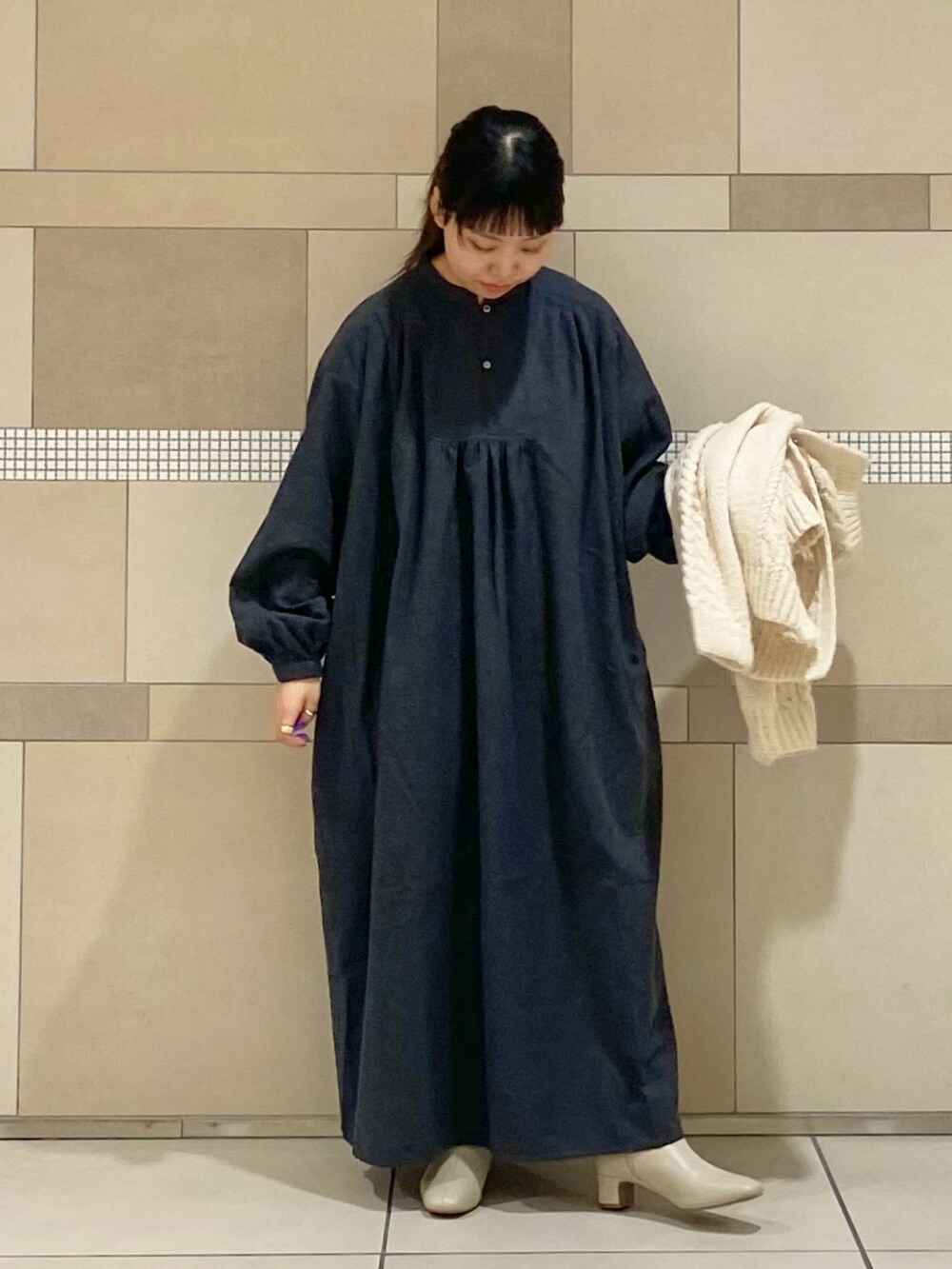 ホワイト系のブーツ、ホワイト系のニット/セーター、ブラック系のワンピースを着用したレディースの秋コーディネートの5枚目の写真