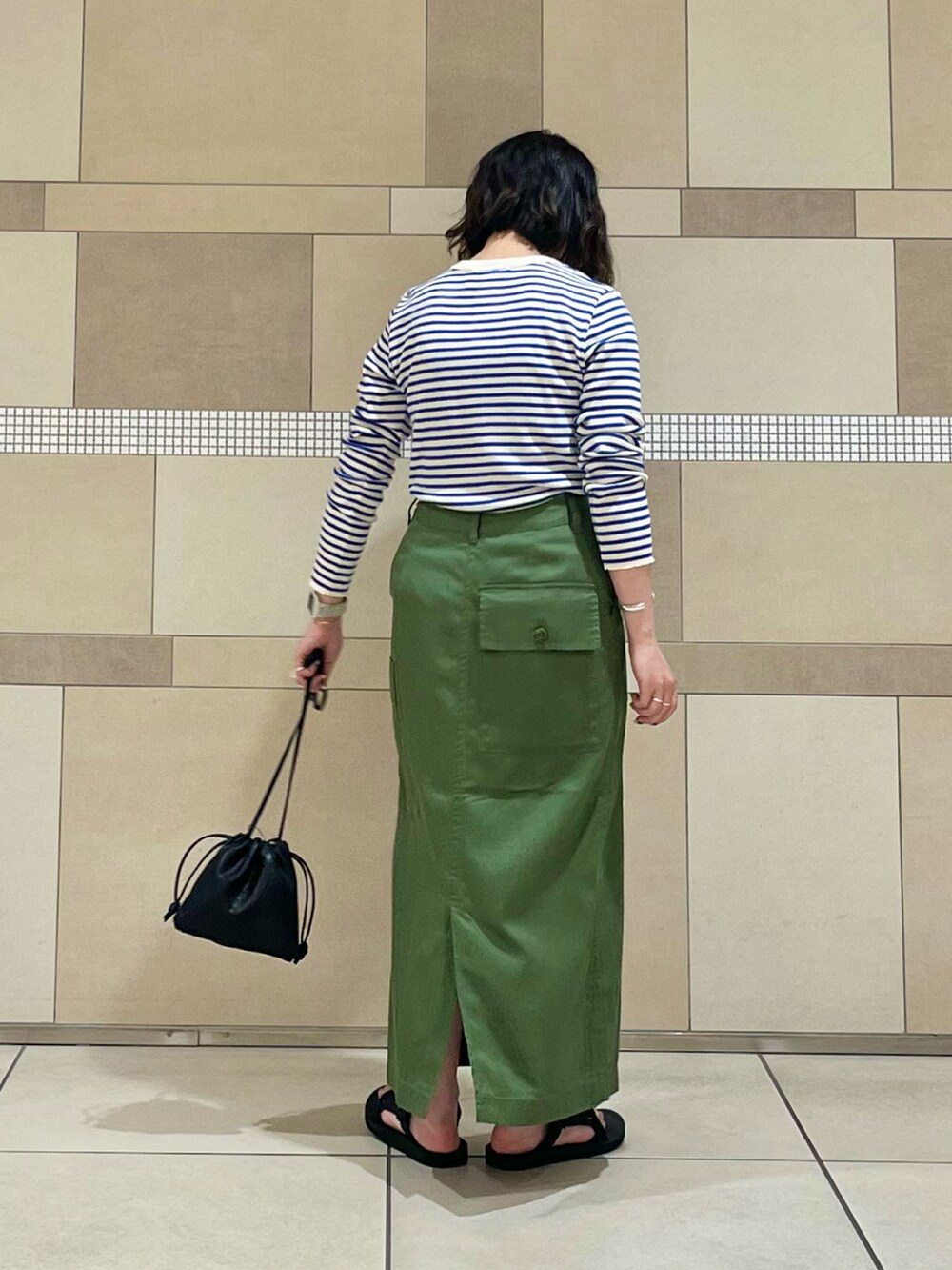 グリーン系のスカート、ブルー系のTシャツ/カットソー、ブラック系のサンダルを着用したレディースの夏コーディネートの4枚目の写真