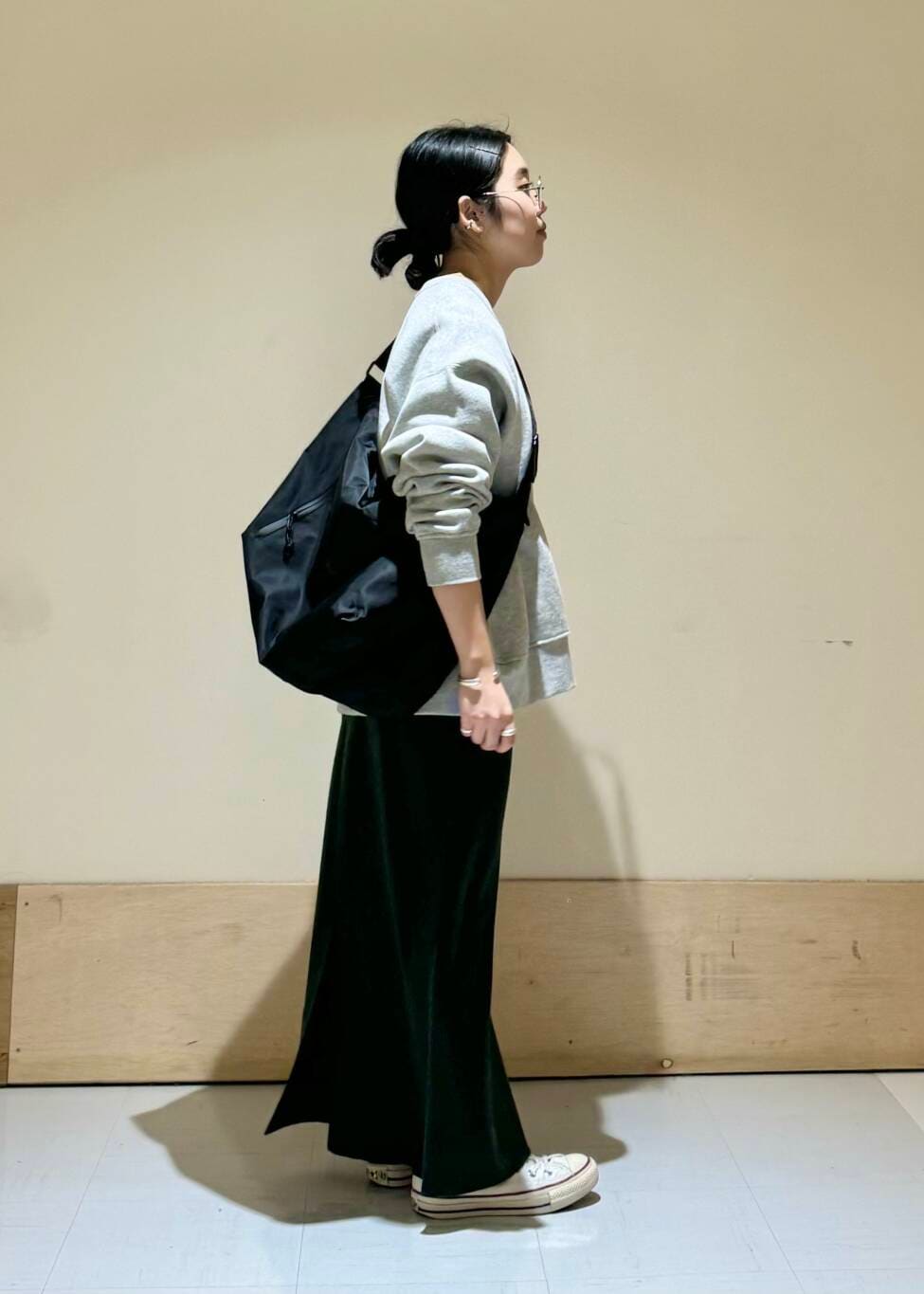 ブラック系のショルダーバッグ、グレー系のスウェット、グリーン系のスカートを着用したレディースの冬コーディネートの2枚目の写真