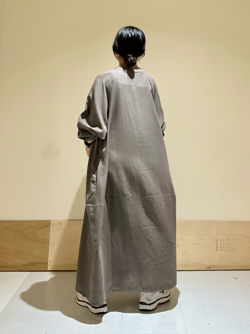 ホワイト系のスニーカー、グレー系のワンピースを着用したレディースの秋コーディネートの3枚目の写真