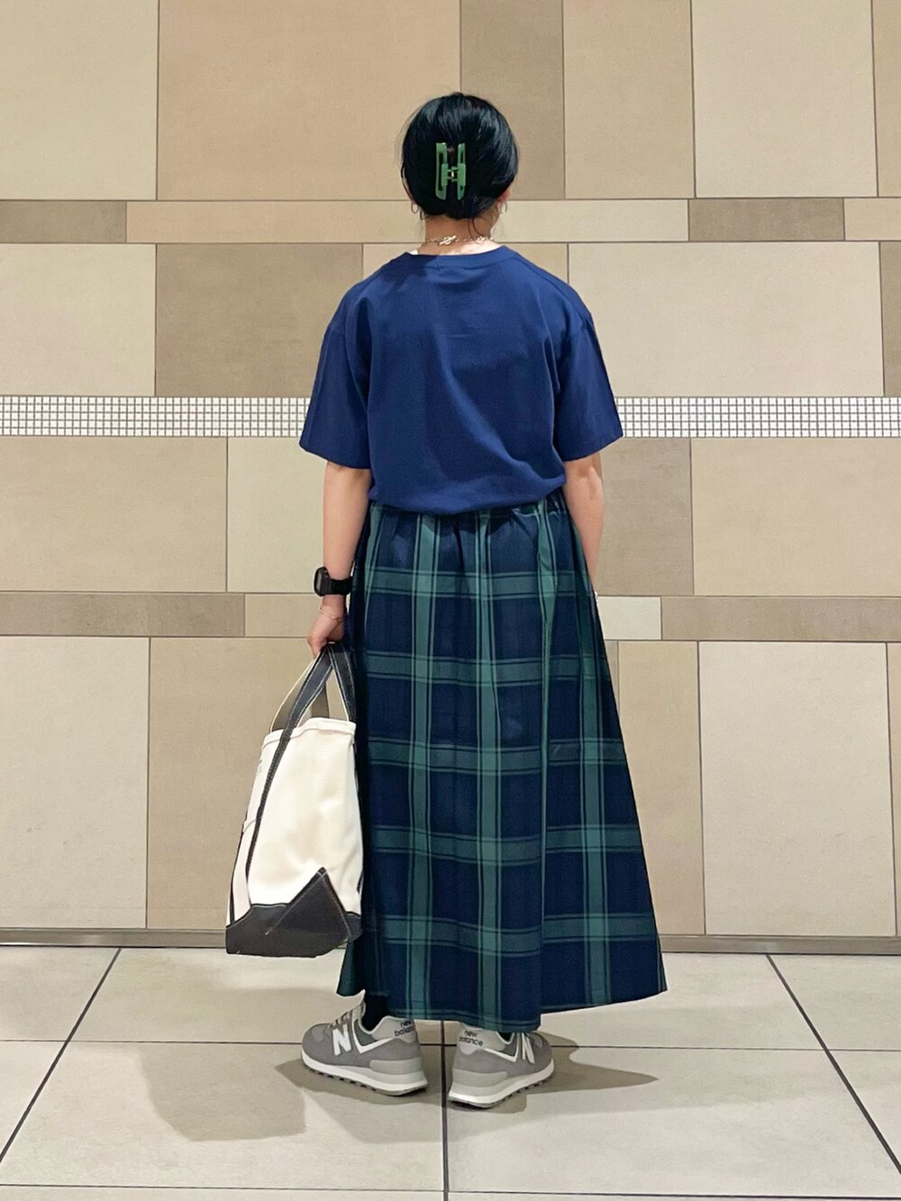 ブルー系のスカート、ブルー系のTシャツ/カットソー、ホワイト系のスニーカーを着用したレディースの夏コーディネートの3枚目の写真