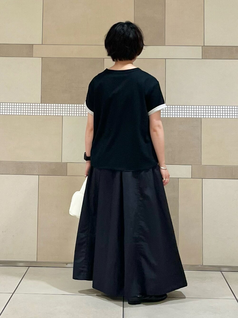 ブラック系のスカート、ブラック系のバレエシューズ、グレー系のTシャツ/カットソーを着用したレディースの夏コーディネートの3枚目の写真