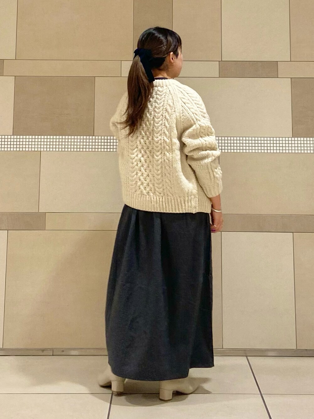 ホワイト系のブーツ、ホワイト系のニット/セーター、ブラック系のワンピースを着用したレディースの秋コーディネートの4枚目の写真