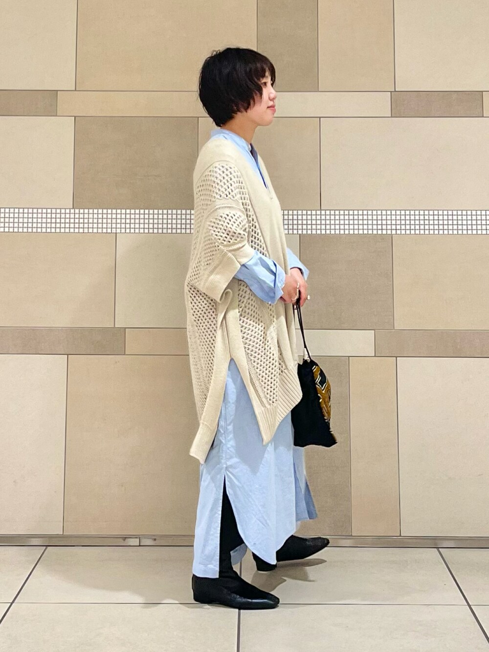 ベージュ系のニット/セーター、ブルー系のワンピース、ブラック系のスカートを着用したレディースの秋コーディネートの3枚目の写真