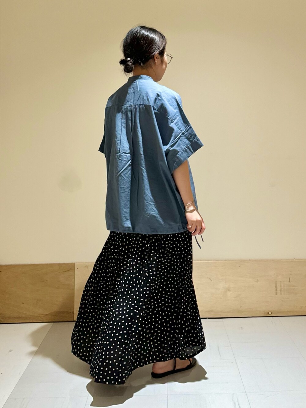 ブラック系のサンダル、ブラック系のスカート、ブルー系のシャツ/ブラウスを着用したレディースの夏コーディネートの3枚目の写真