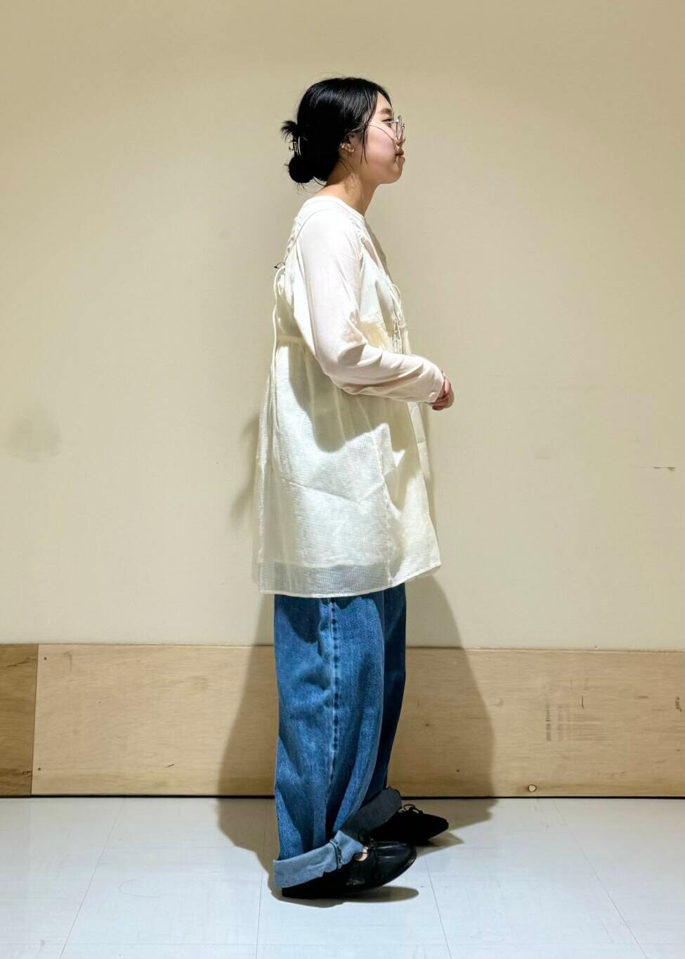 ブルー系のデニムパンツ、ブラック系のバレエシューズ、ホワイト系のキャミソールを着用したレディースの夏コーディネートの3枚目の写真