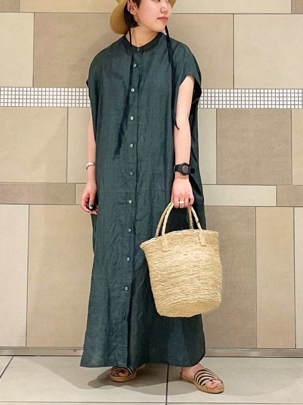 グリーン系のワンピース、ベージュ系のサンダル、ベージュ系のハットを着用したレディースの春コーディネートの2枚目の写真