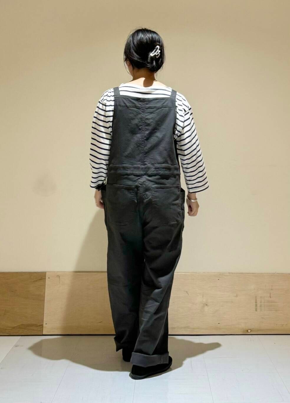 ブラック系のその他シューズ、レッド系のTシャツ/カットソー、グレー系のサロペット/オーバーオールを着用したレディースの秋コーディネートの2枚目の写真