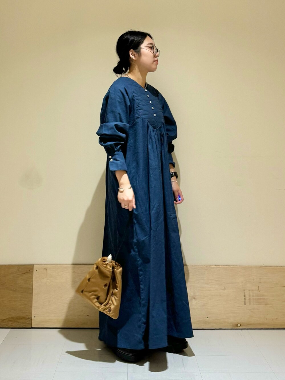 ブラック系のブーツ、ブラウン系のショルダーバッグ、ブルー系のワンピースを着用したレディースの秋コーディネートの2枚目の写真