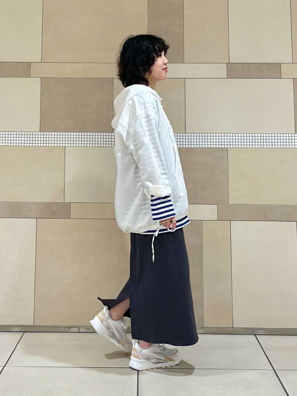 ホワイト系のパーカー、ブルー系のTシャツ/カットソー、グレー系のスカートを着用したレディースの春コーディネートの2枚目の写真