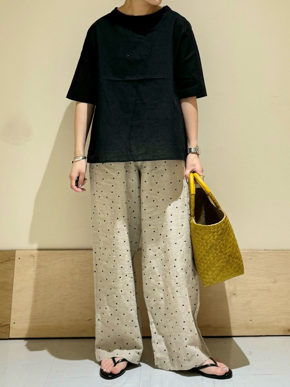 ブラック系のシャツ/ブラウス、ベージュ系のその他パンツ、イエロー系のトートバッグを着用したレディースの夏コーディネートの2枚目の写真