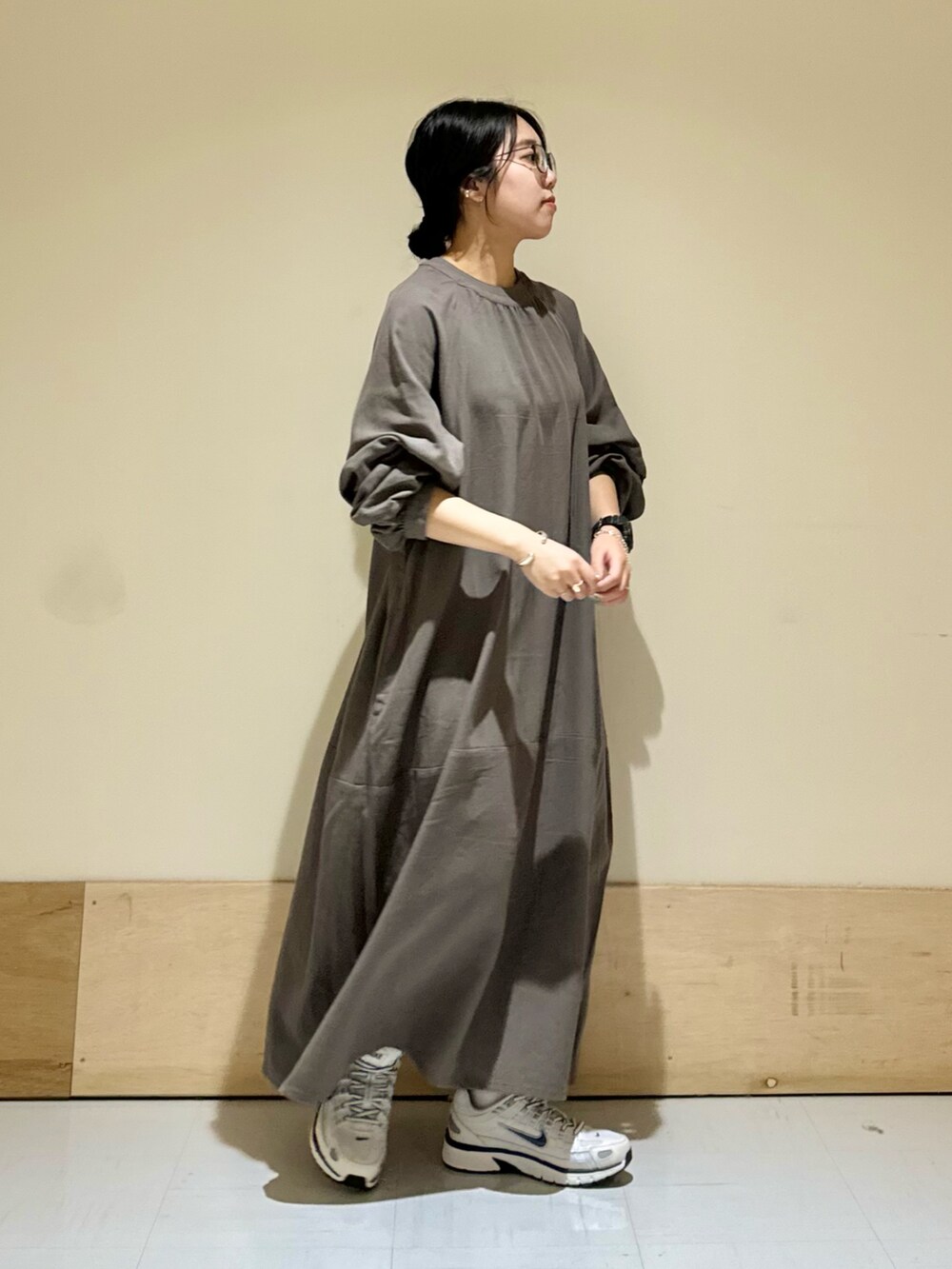 ホワイト系のスニーカー、グレー系のワンピースを着用したレディースの秋コーディネートの2枚目の写真