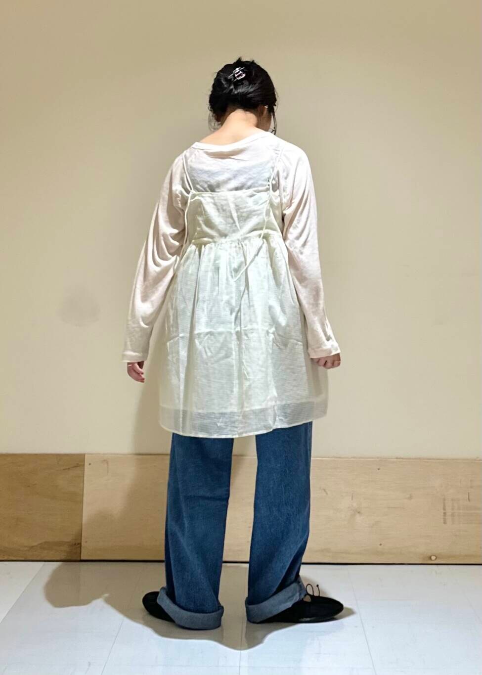 ブルー系のデニムパンツ、ブラック系のバレエシューズ、ホワイト系のキャミソールを着用したレディースの夏コーディネートの4枚目の写真