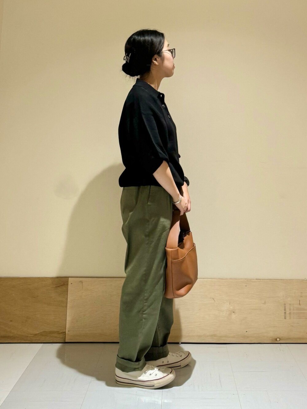 イエロー系のショルダーバッグ、ブラック系のニット/セーター、グリーン系のその他パンツを着用したレディースの夏コーディネートの2枚目の写真