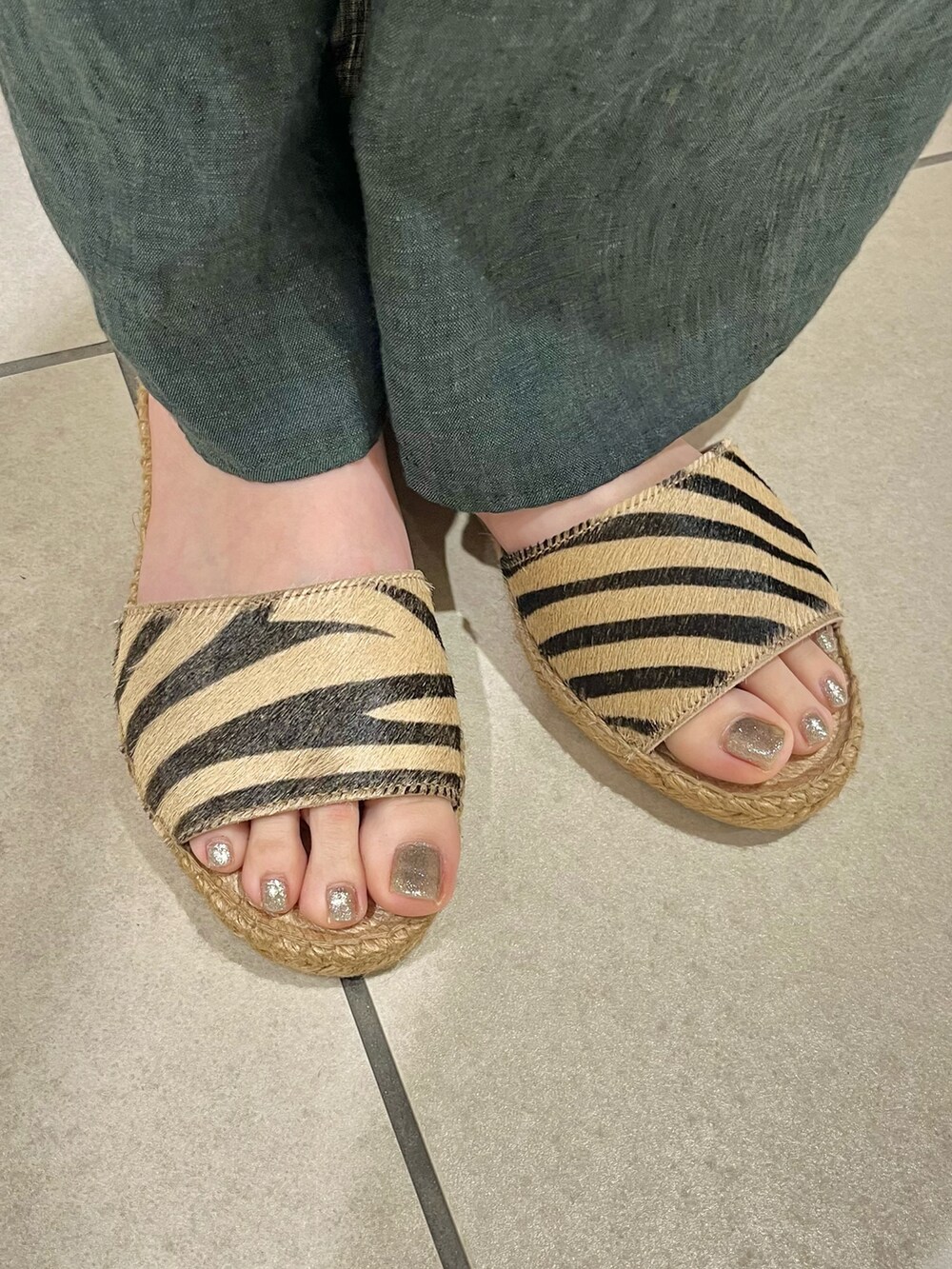 グリーン系のワンピース、ベージュ系のサンダル、ベージュ系のハットを着用したレディースの春コーディネートの5枚目の写真