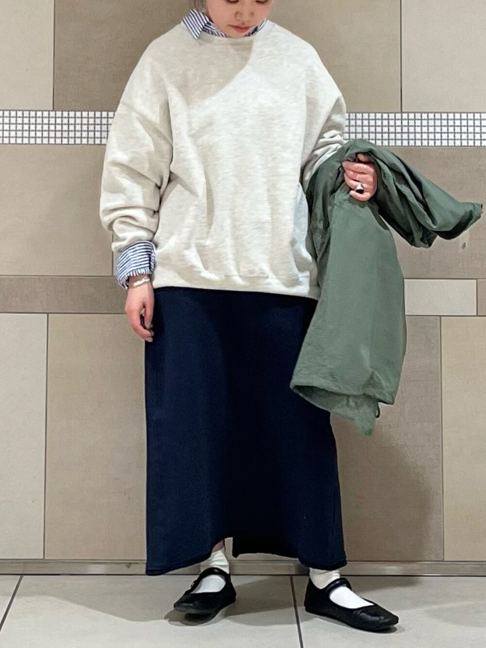 グレー系のスウェット、グレー系のスカート、ブルー系のシャツ/ブラウスを着用したレディースの冬コーディネートの2枚目の写真