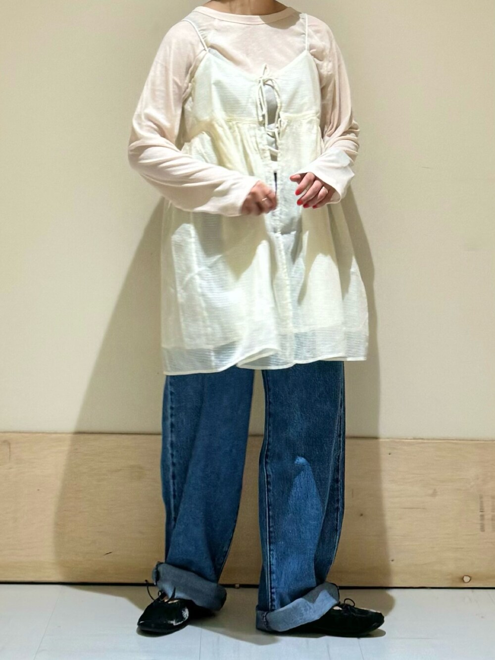 ホワイト系のキャミソール、ブラック系のバレエシューズ、ブルー系のデニムパンツを着用したレディースの夏コーディネートの2枚目の写真