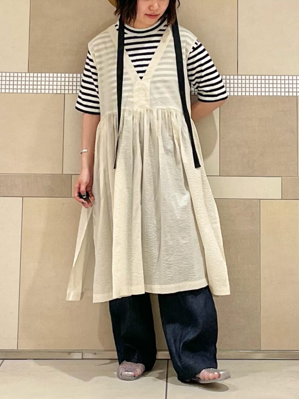 ブルー系のTシャツ/カットソー、ホワイト系のワンピース、ブルー系のデニムパンツを着用したレディースの春コーディネートの2枚目の写真