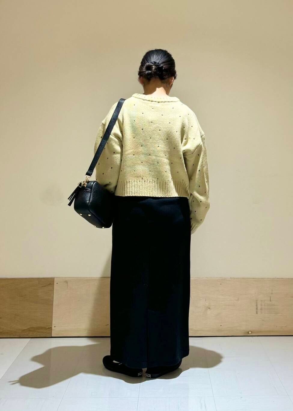 ブラック系のショルダーバッグ、ブラック系のスカート、ベージュ系のカーディガン/ボレロを着用したレディースの秋コーディネートの3枚目の写真