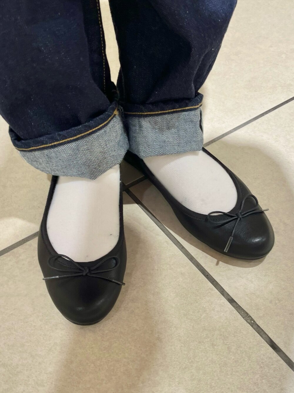 レッド系のニット/セーター、レッド系のカーディガン/ボレロ、ブラック系のショルダーバッグを着用したレディースの春コーディネートの5枚目の写真