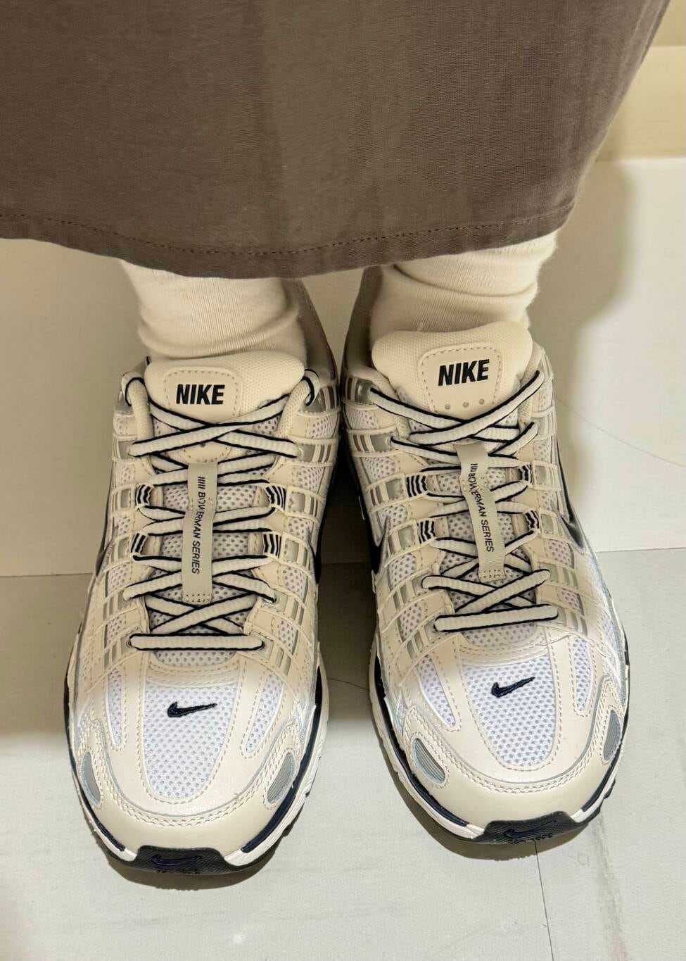 グレー系のワンピース、ホワイト系のスニーカーを着用したレディースの秋コーディネートの4枚目の写真