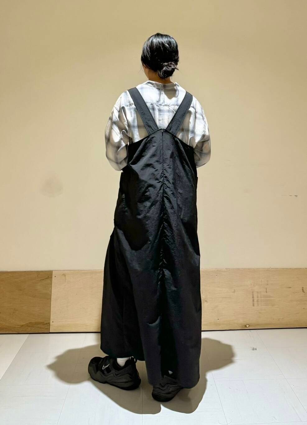 ブラック系のワンピース、グレー系のシャツ/ブラウス、グリーン系のバックパック/リュックを着用したレディースの秋コーディネートの3枚目の写真