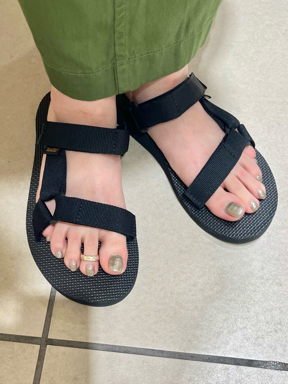 グリーン系のスカート、ブルー系のTシャツ/カットソー、ブラック系のサンダルを着用したレディースの夏コーディネートの5枚目の写真