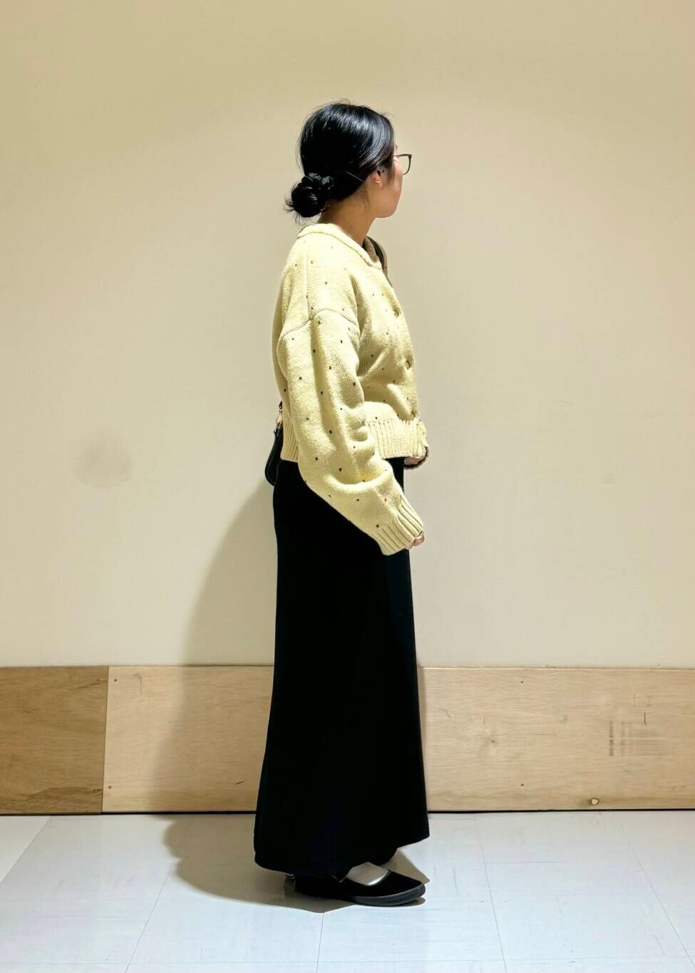 ブラック系のショルダーバッグ、ブラック系のスカート、ベージュ系のカーディガン/ボレロを着用したレディースの秋コーディネートの2枚目の写真