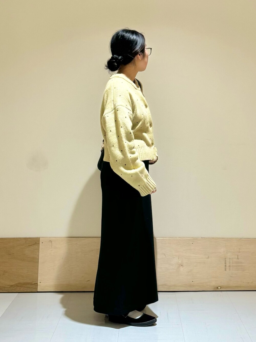 ブラック系のショルダーバッグ、ブラック系のスカート、ベージュ系のカーディガン/ボレロを着用したレディースの秋コーディネートの2枚目の写真