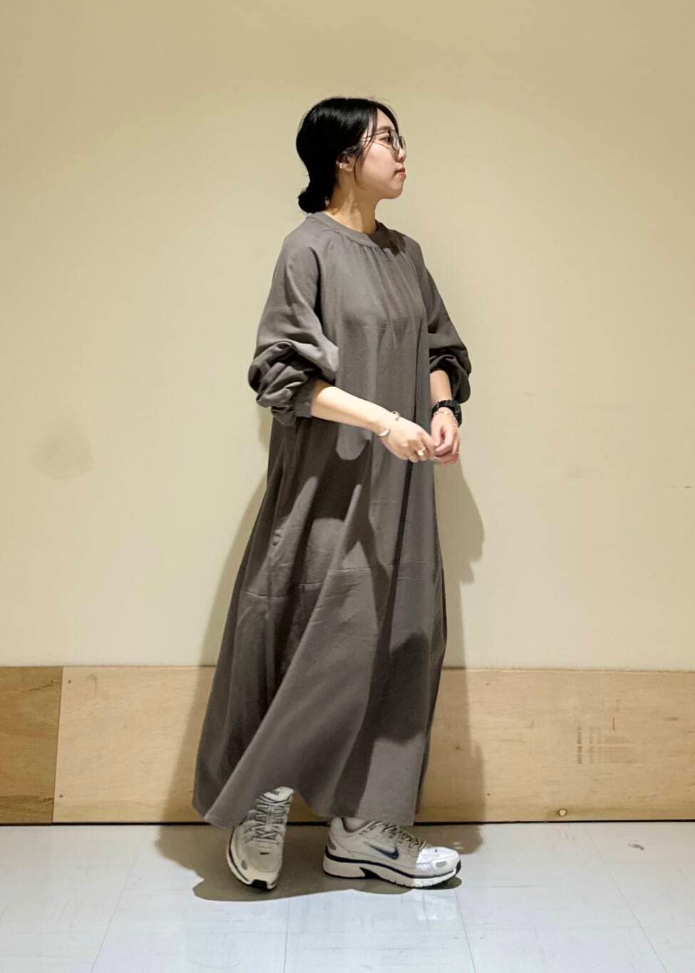 グレー系のワンピース、ホワイト系のスニーカーを着用したレディースの秋コーディネートの2枚目の写真