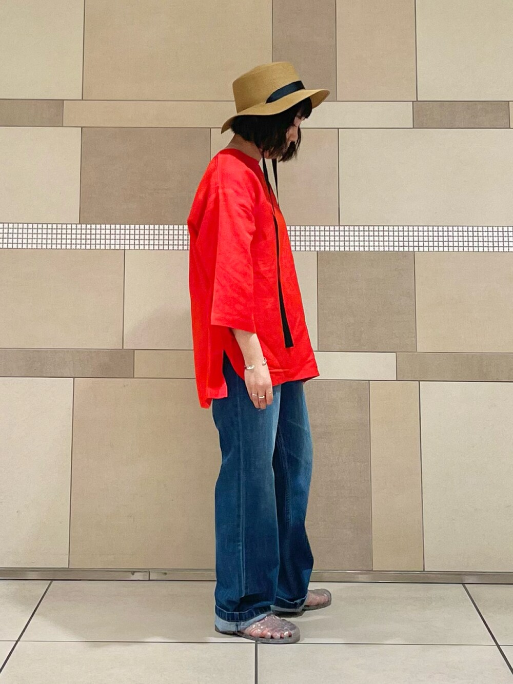 レッド系のTシャツ/カットソー、ブルー系のデニムパンツを着用したレディースの夏コーディネートの3枚目の写真