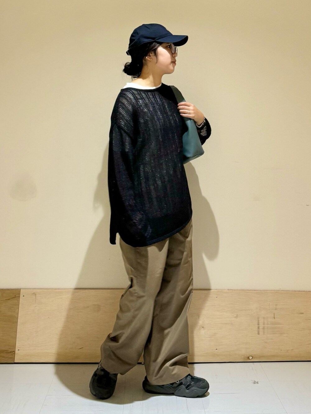ブルー系のショルダーバッグ、ブラック系のニット/セーター、ブラウン系のその他パンツを着用したレディースの秋コーディネートの2枚目の写真