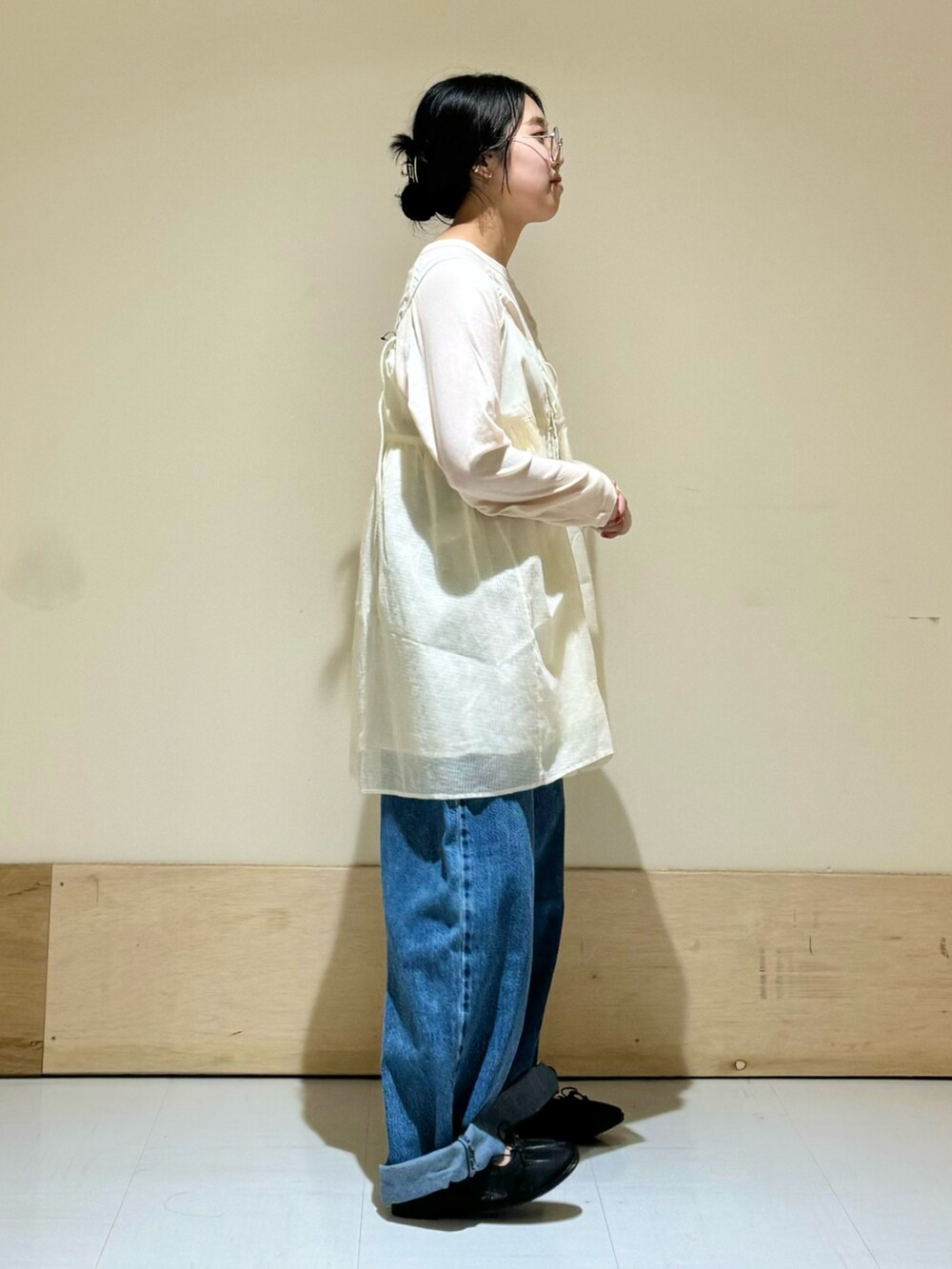 ホワイト系のキャミソール、ブラック系のバレエシューズ、ブルー系のデニムパンツを着用したレディースの夏コーディネートの3枚目の写真