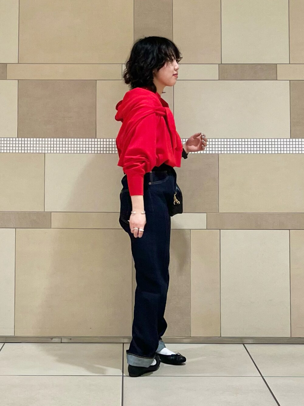 レッド系のニット/セーター、レッド系のカーディガン/ボレロ、ブラック系のショルダーバッグを着用したレディースの春コーディネートの2枚目の写真