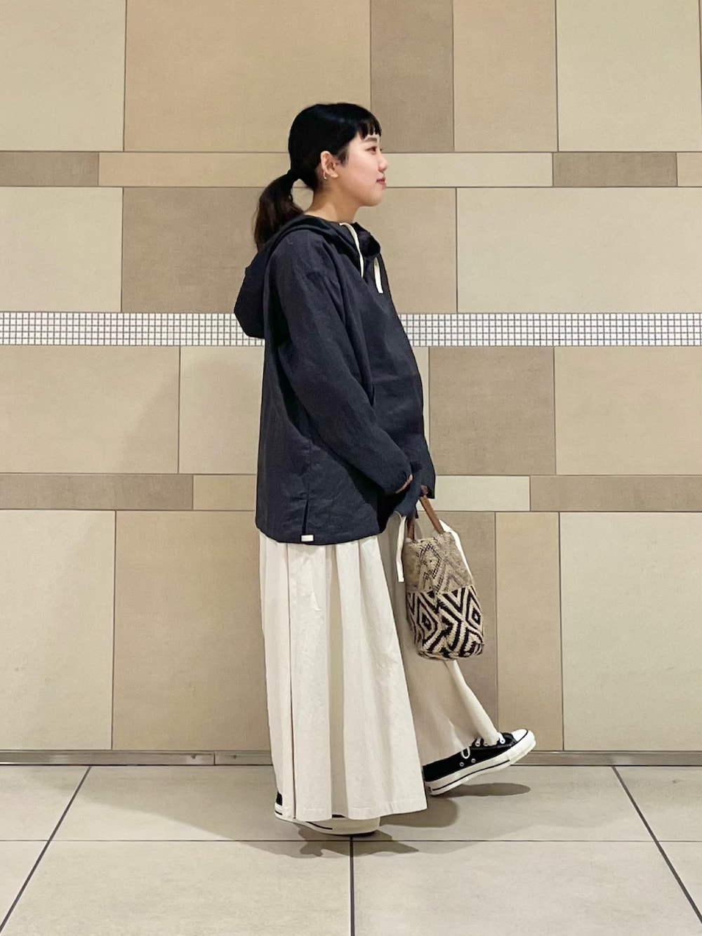 ブラック系のその他アウター、ホワイト系のスカート、ブラック系のトートバッグを着用したレディースの春コーディネートの3枚目の写真