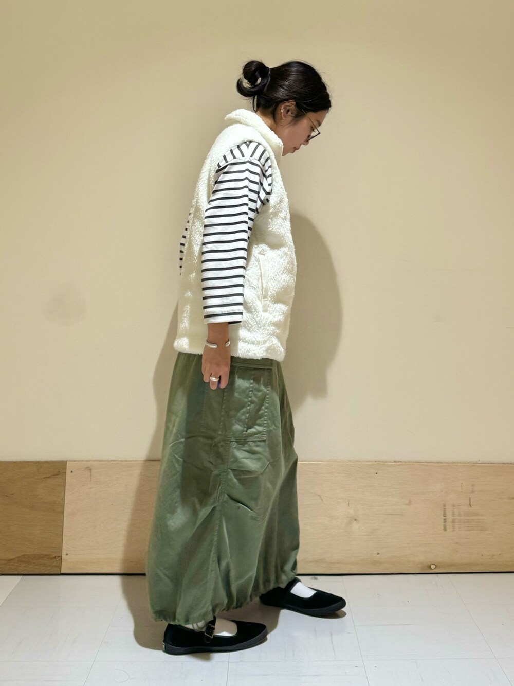 ホワイト系のトップス、ホワイト系のTシャツ/カットソー、グリーン系のスカートを着用したレディースの秋コーディネートの2枚目の写真