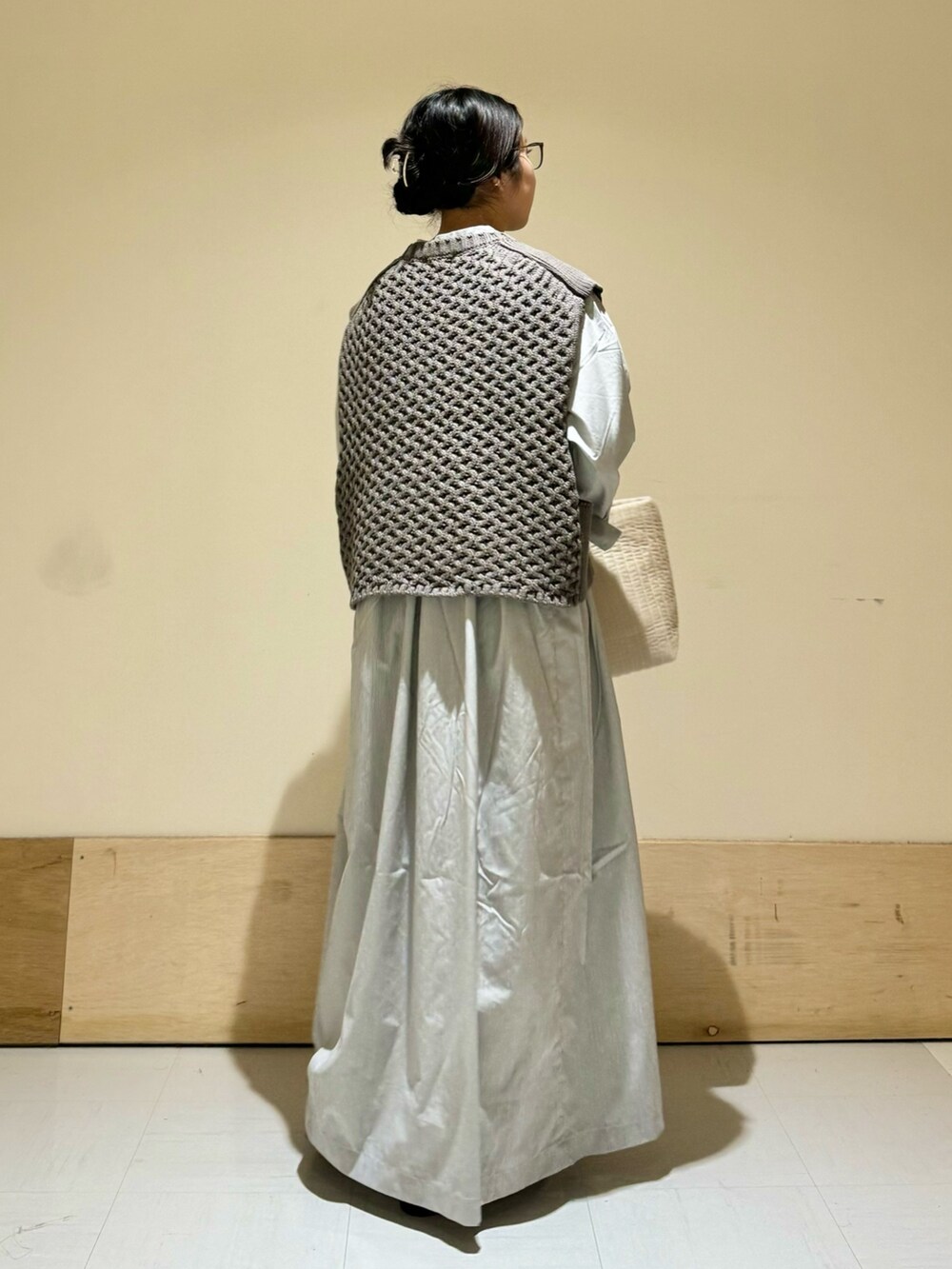 グレー系のベスト、ホワイト系のトートバッグ、ブラック系のバレエシューズを着用したレディースの秋コーディネートの3枚目の写真