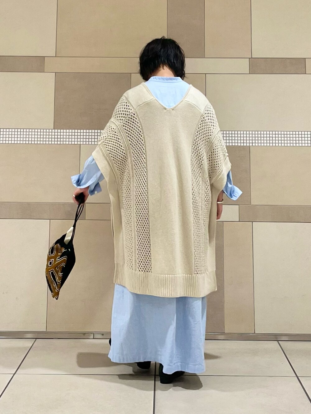 ベージュ系のニット/セーター、ブルー系のワンピース、ブラック系のスカートを着用したレディースの秋コーディネートの4枚目の写真