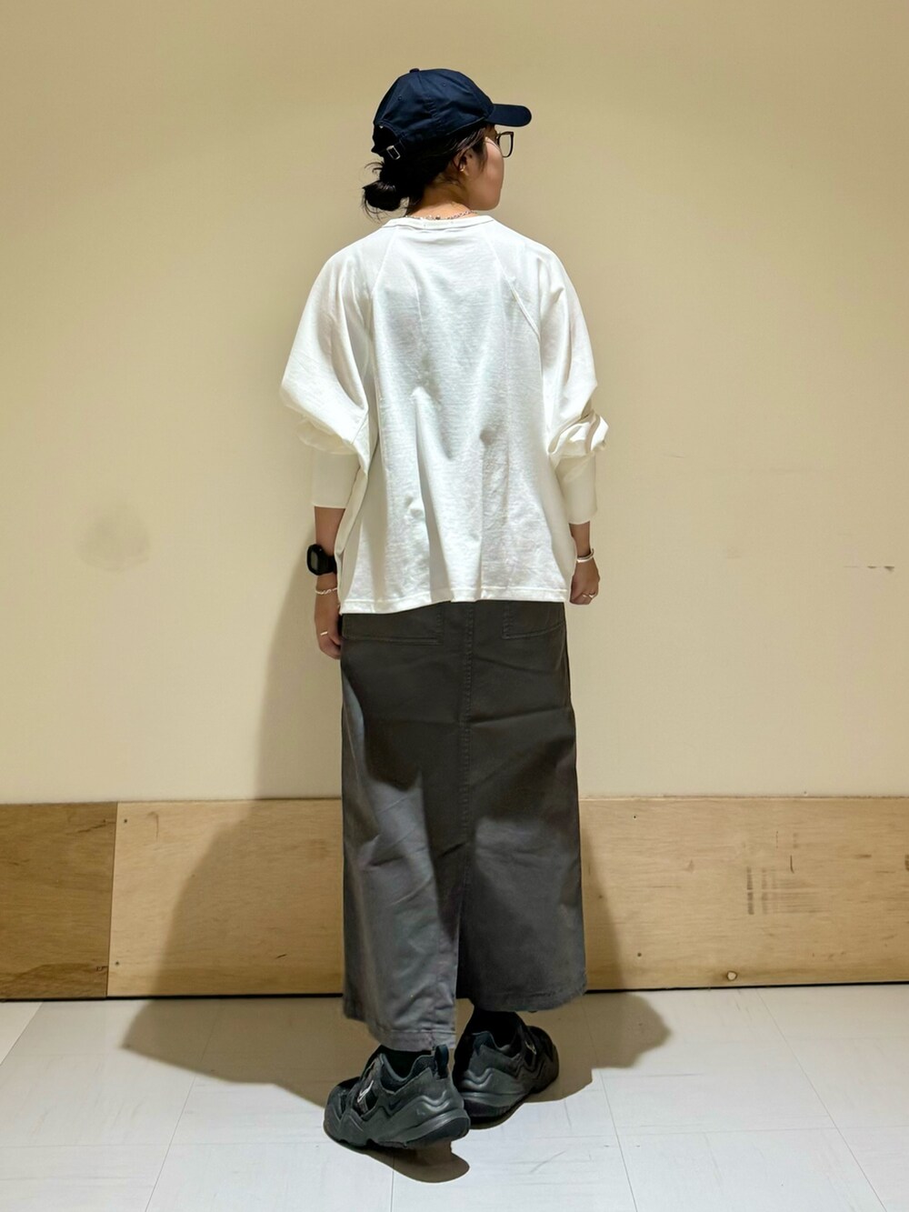 グレー系のスカート、ホワイト系のTシャツ/カットソーを着用したレディースの秋コーディネートの4枚目の写真