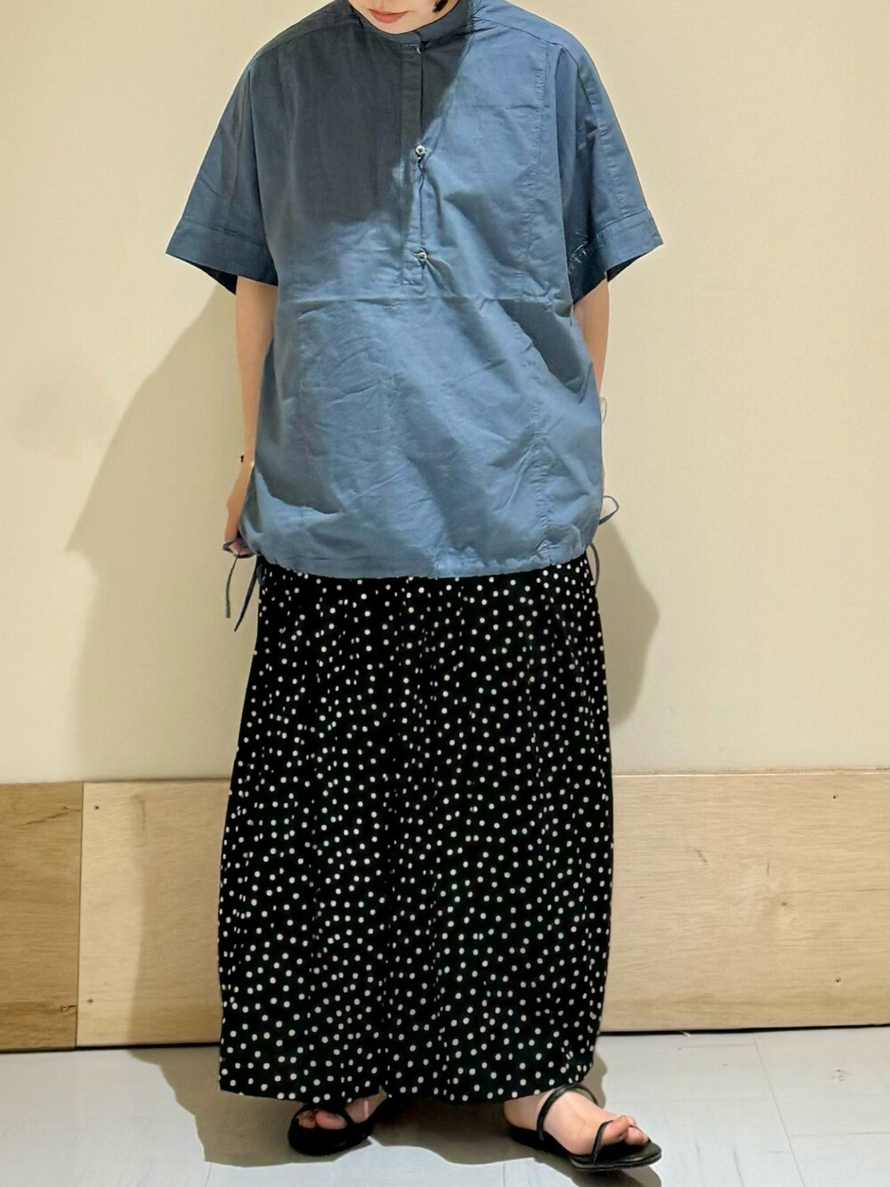 ブラック系のサンダル、ブラック系のスカート、ブルー系のシャツ/ブラウスを着用したレディースの夏コーディネートの2枚目の写真