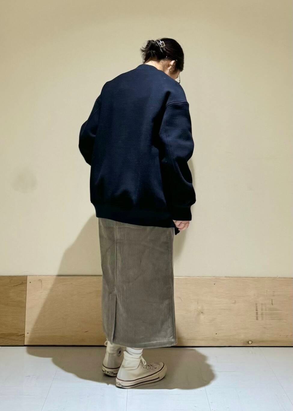 オレンジ系のニット/セーター、ブルー系のスタジャン、ブラウン系のスカートを着用したレディースの冬コーディネートの2枚目の写真