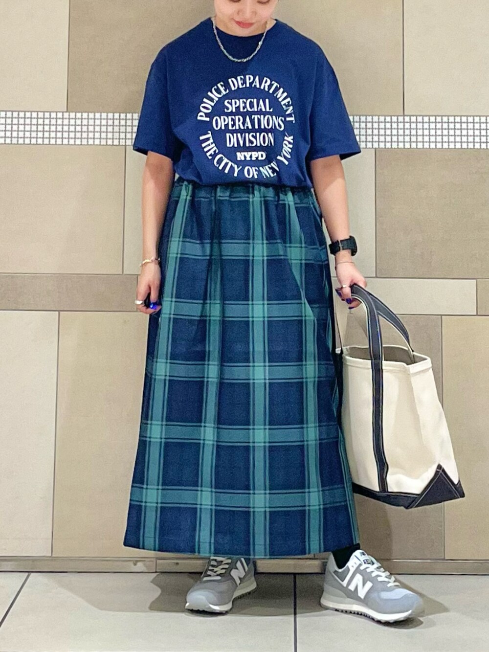 ブルー系のスカート、ブルー系のTシャツ/カットソー、ホワイト系のスニーカーを着用したレディースの夏コーディネートの2枚目の写真