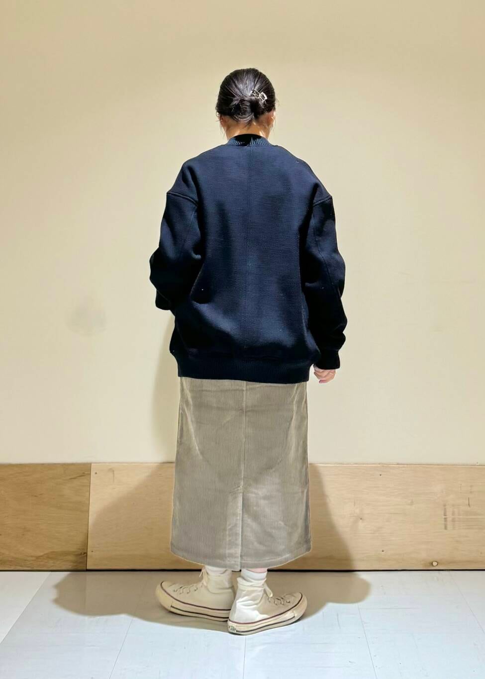 オレンジ系のニット/セーター、ブルー系のスタジャン、ブラウン系のスカートを着用したレディースの冬コーディネートの3枚目の写真