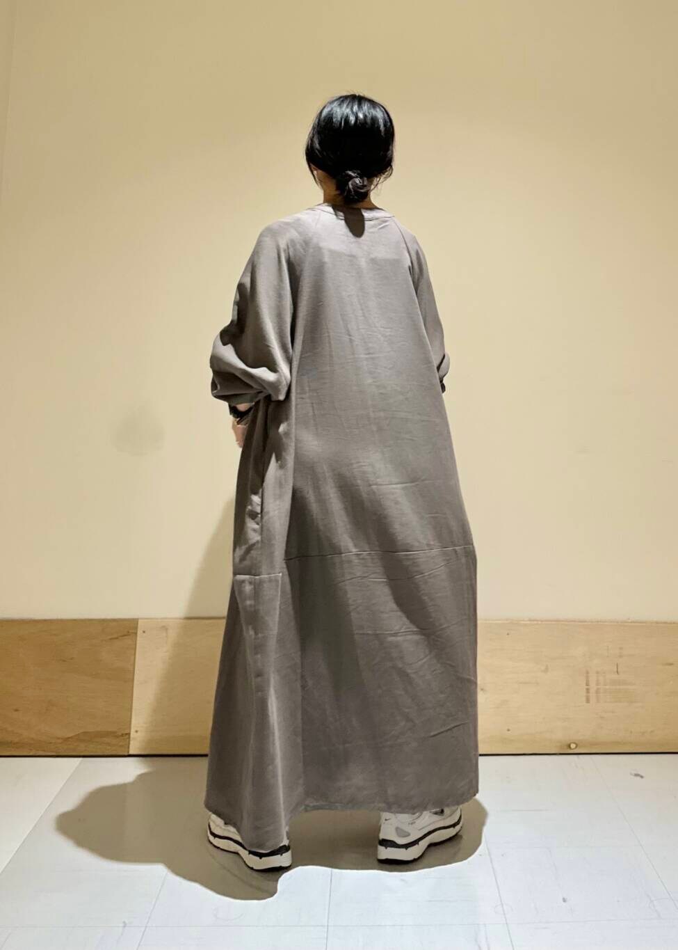 グレー系のワンピース、ホワイト系のスニーカーを着用したレディースの秋コーディネートの3枚目の写真