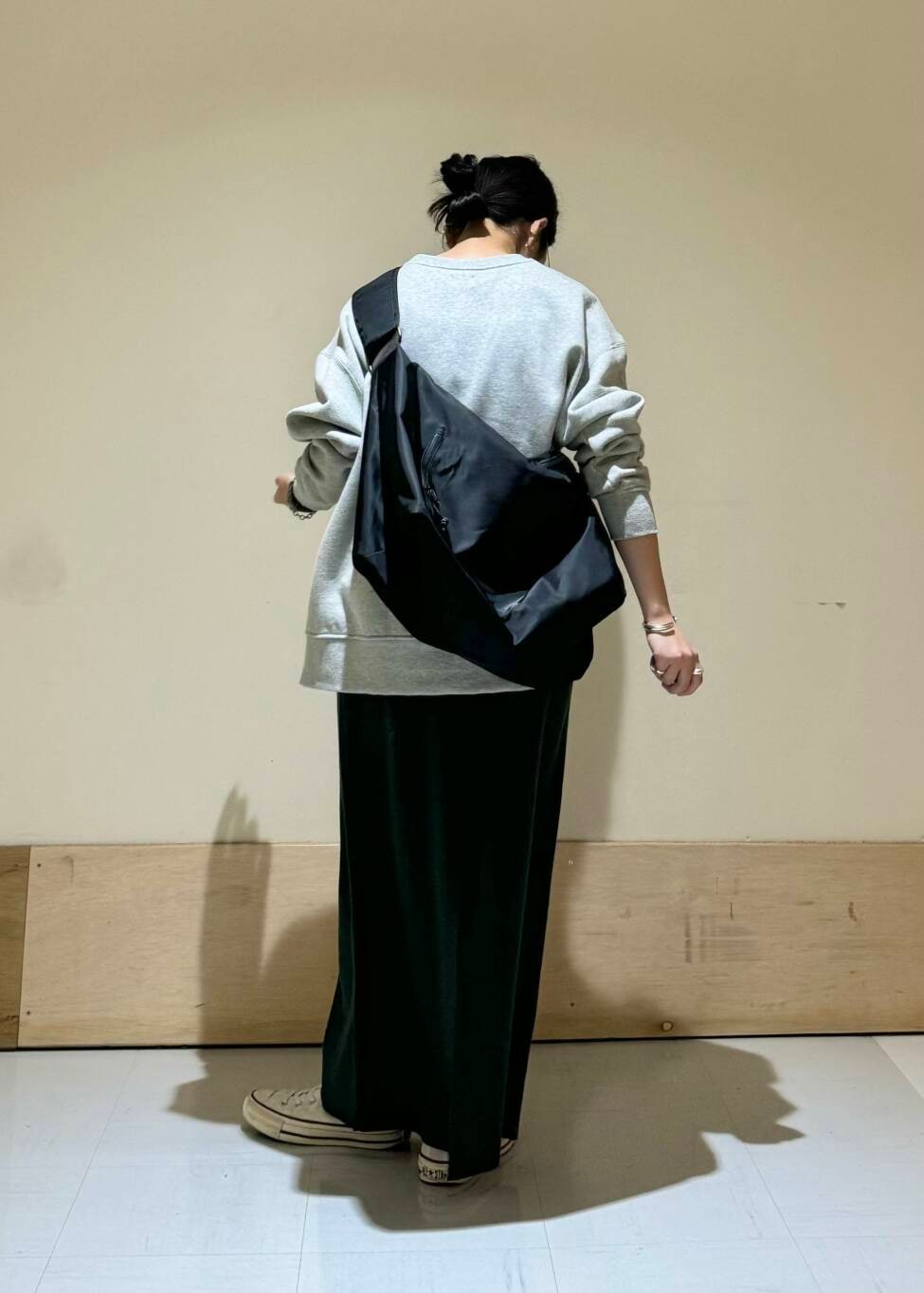 ブラック系のショルダーバッグ、グレー系のスウェット、グリーン系のスカートを着用したレディースの冬コーディネートの3枚目の写真