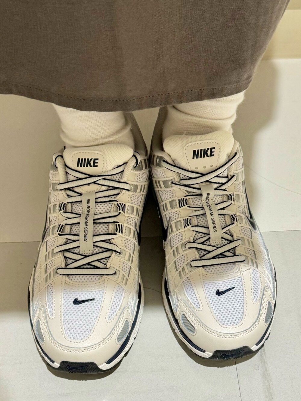 ホワイト系のスニーカー、グレー系のワンピースを着用したレディースの秋コーディネートの4枚目の写真