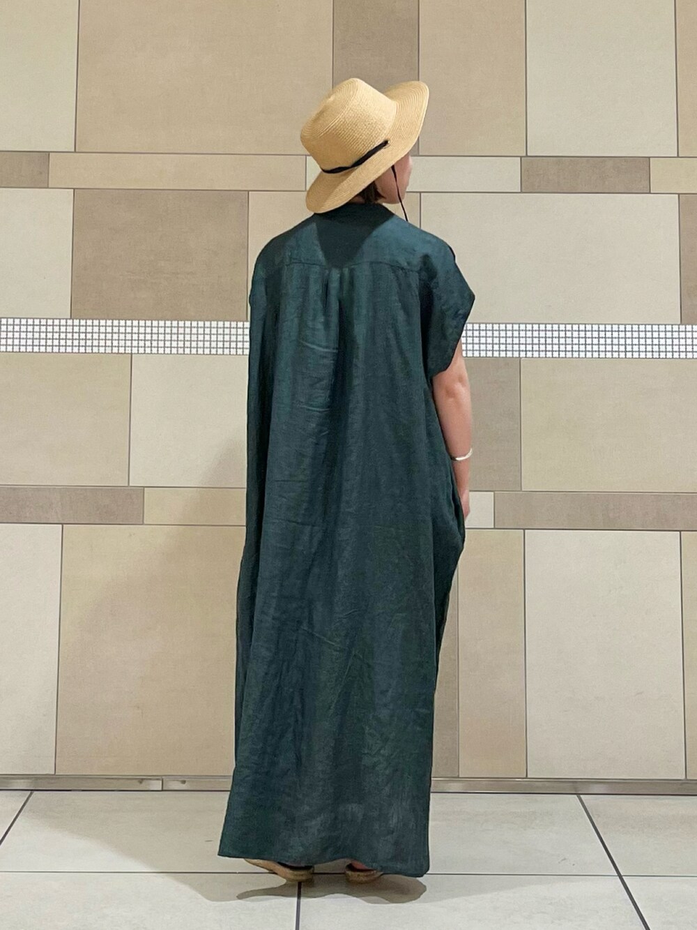 グリーン系のワンピース、ベージュ系のサンダル、ベージュ系のハットを着用したレディースの春コーディネートの4枚目の写真