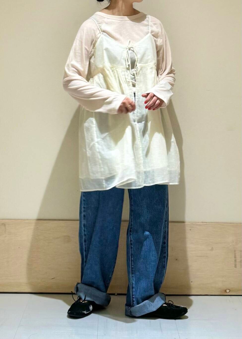 ブルー系のデニムパンツ、ブラック系のバレエシューズ、ホワイト系のキャミソールを着用したレディースの夏コーディネートの2枚目の写真