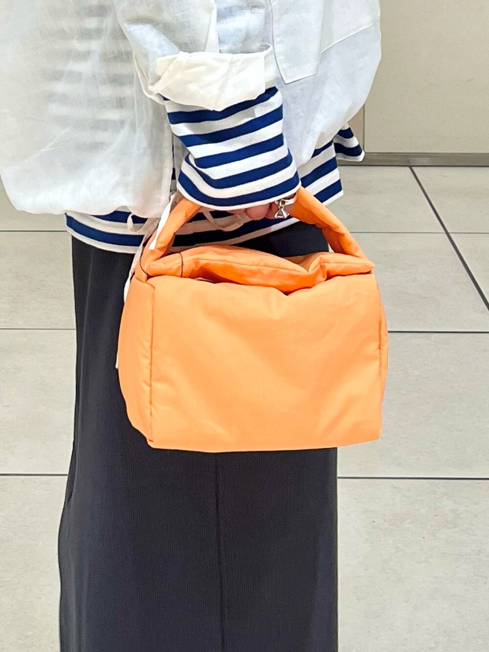 ホワイト系のパーカー、ブルー系のTシャツ/カットソー、グレー系のスカートを着用したレディースの春コーディネートの4枚目の写真