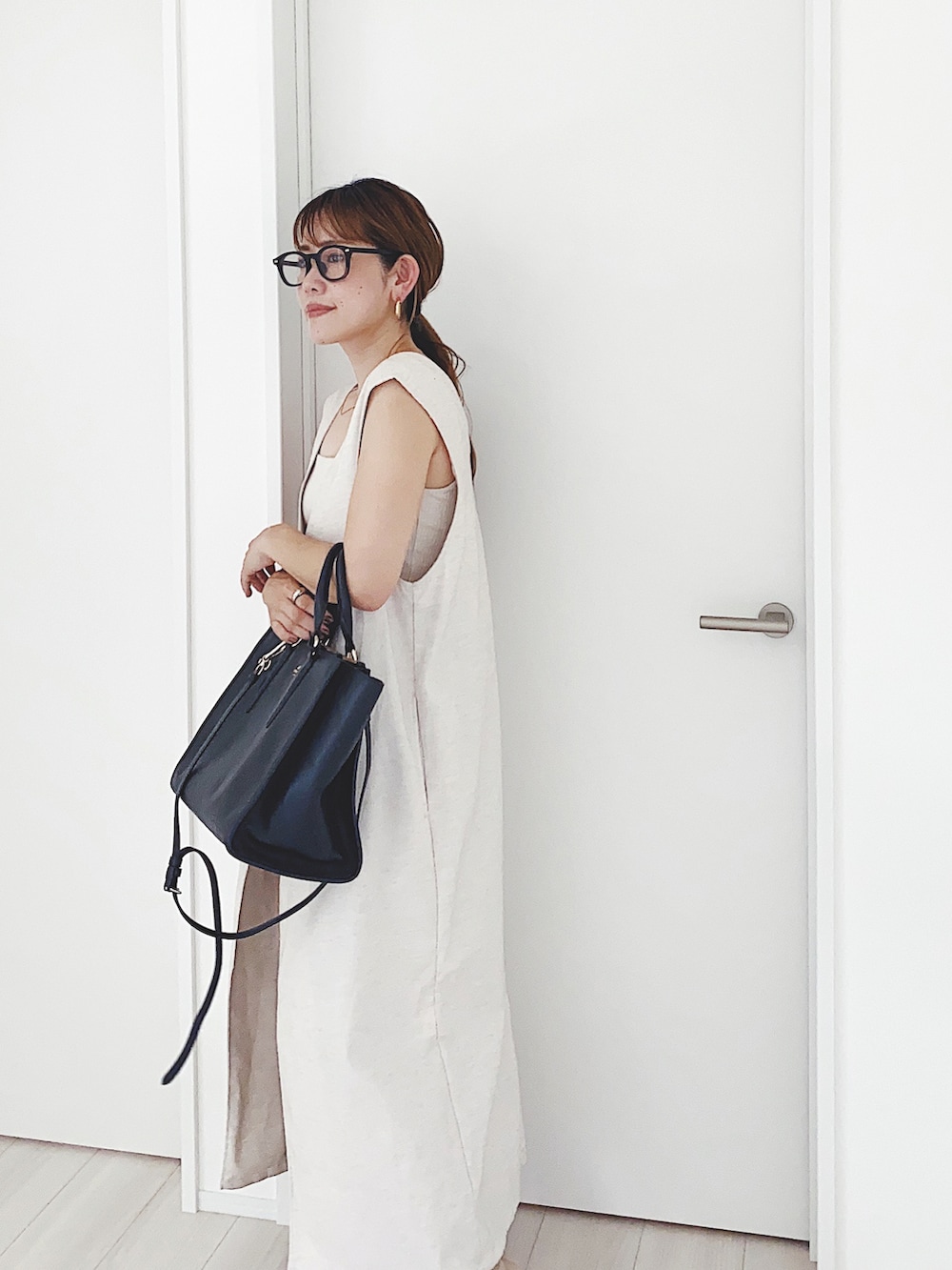 ブラック系のサンダル、ベージュ系のワンピース、ベージュ系のスラックスを着用したレディースの夏コーディネートの4枚目の写真